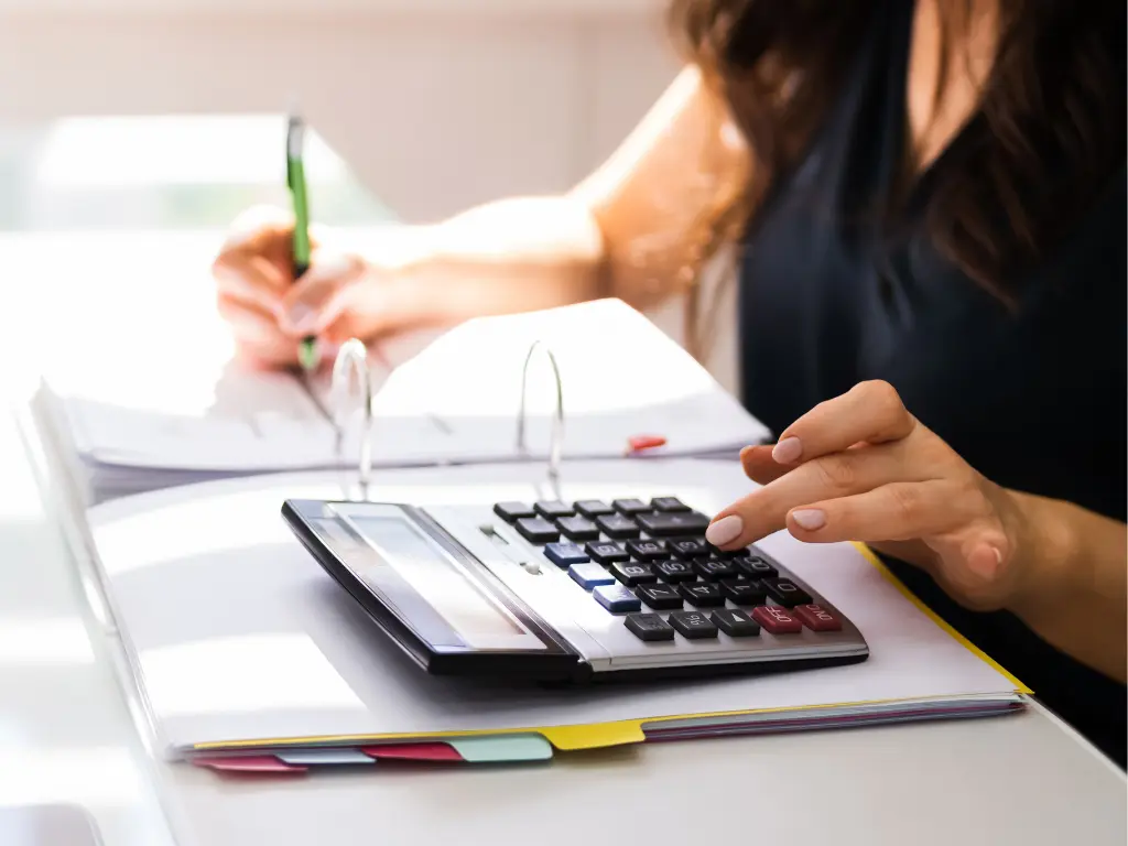 A woman using a calculator for accurate financial reporting.
